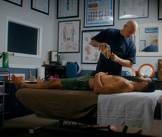 Peter C. Lowden providing therapeutic bodywork in a clinical treatment room